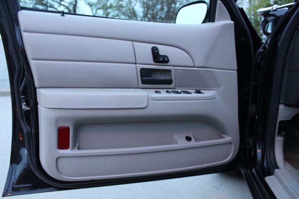Gray driver's door panel with power mirror control, window switches and map pocket
