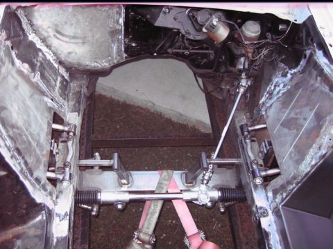 1992 Ford Mustang - Close-up of a car's steering rack and front suspension components during a build.