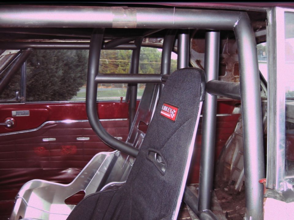 racing seat with Kirkey logo, roll cage, and red interior panels