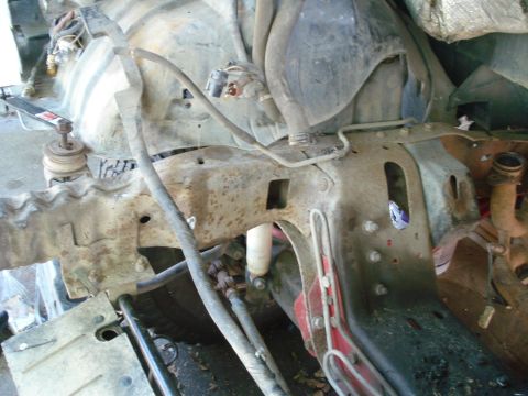 1993 Ford Bronco - Close-up view of a vehicle's corroded frame and engine bay components, suggesting a rebuild or repair process.