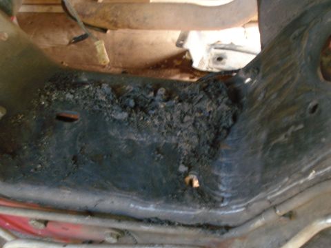 1993 Ford Bronco - Accumulated debris and rust on an underbody part, possibly related to engine rebuilding.