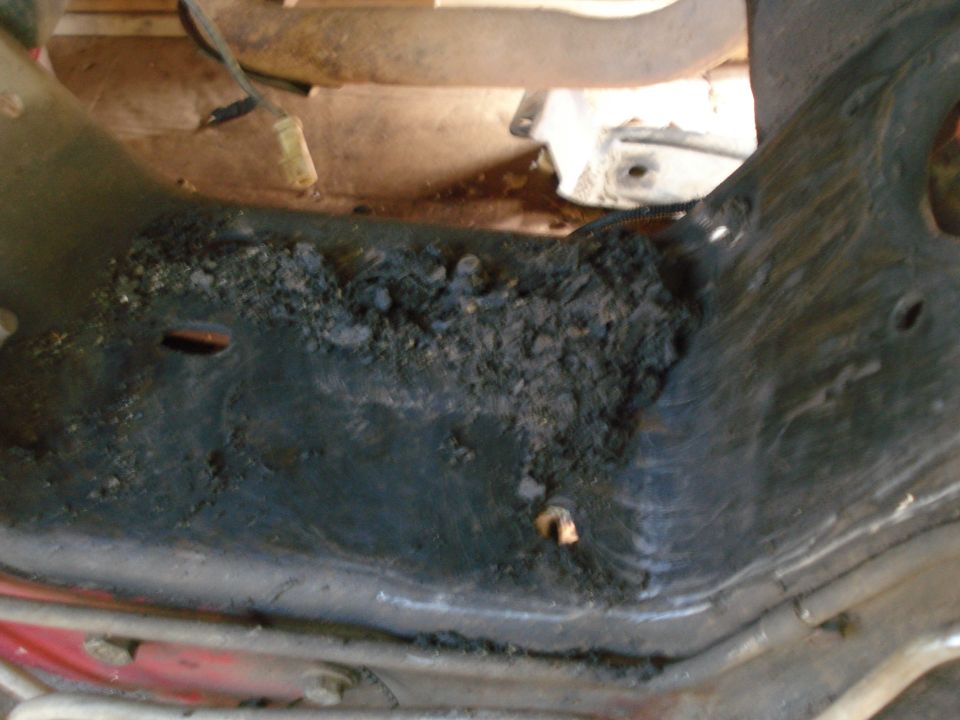 Underbody part with accumulated debris and rust
