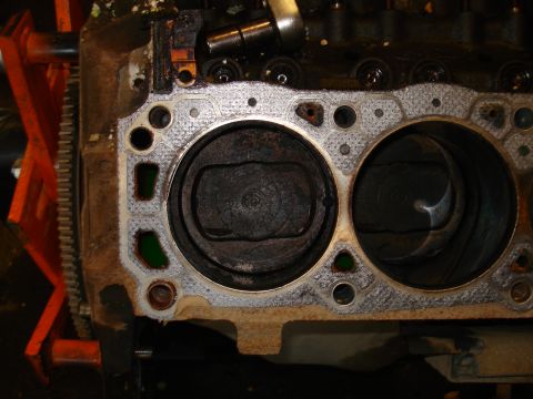1993 Ford Bronco - Close-up of an engine block showing two cylinders and pistons, with a corroded gasket.