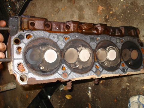 1993 Ford Bronco - A used engine cylinder head shows signs of wear and tear, with carbon buildup around the valves.