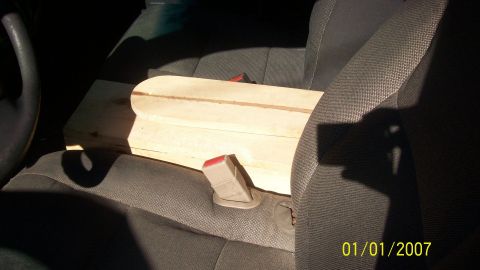 2004 Ford Crown Victoria - A wooden object is placed on the passenger seat of a car, obscuring the view of the dashboard and steering wheel.