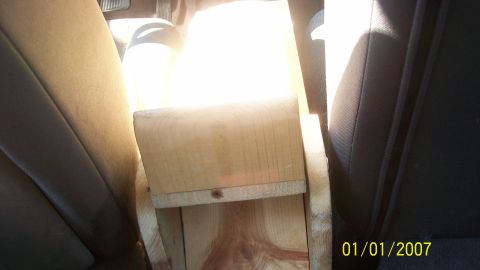 2004 Ford Crown Victoria - Wooden console box installed between car seats, obscuring the view of the interior.