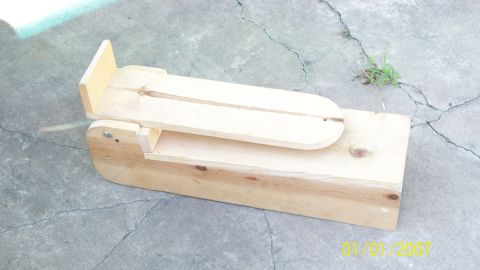 2004 Ford Crown Victoria - A wooden device sits on a concrete surface, with a visible Supermotors watermark.