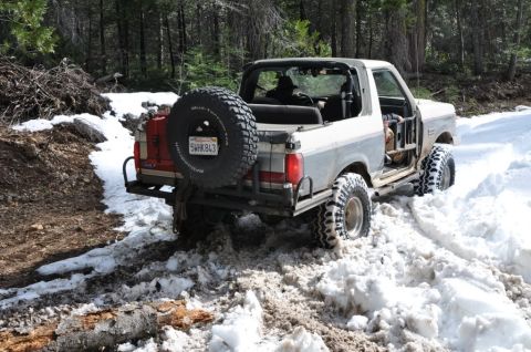 1991 Ford Bronco - This 1991 Ford Bronco is navigating a snowy trail with its doors removed.
