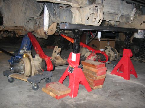 1989 Ford Bronco - Vehicle undercarriage with suspension components on jack stands, indicating maintenance or repair work.