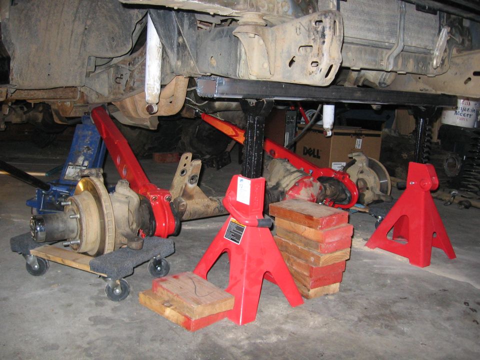 Red suspension arms and axle assembly on jack stands