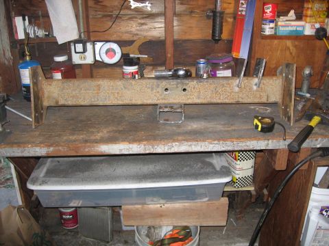 1989 Ford Bronco - A metal beam, likely a vehicle part, sits on a workbench with tools and supplies.