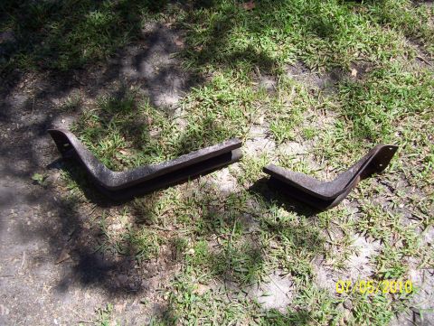 1978 Ford Bronco - Two metal brackets are shown on a grassy surface. The Supermotors.net logo is visible in the lower right corner.