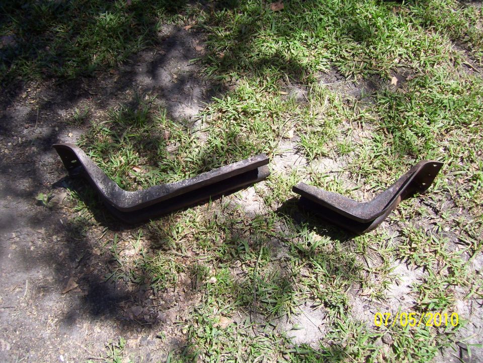 Two metal brackets on grass. Supermotors.net logo visible