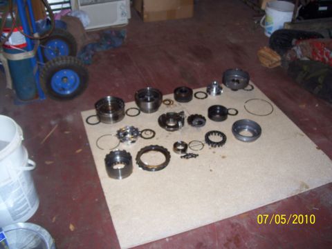 1978 Ford Bronco - Disassembled transmission parts are laid out on a board for inspection or repair.