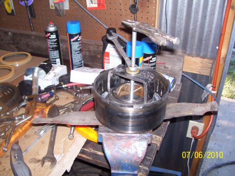 1978 Ford Bronco - Workbench setup with a transmission part being worked on, surrounded by various tools and automotive supplies.