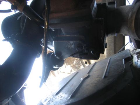 1976 Ford F-250 - Close-up of vehicle undercarriage, showing exhaust system and suspension components. Text 'SUPERMOTORS.NET' is visible.