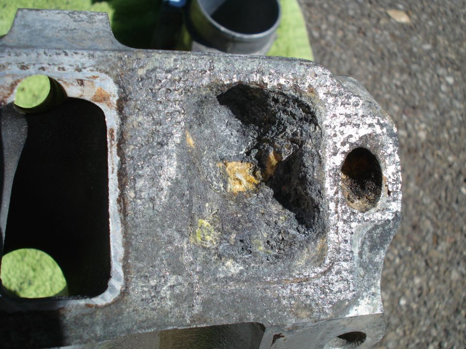 Damaged engine part with heavy corrosion and debris