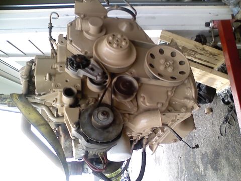 1990 Ford Bronco - Engine assembly with various components visible, suspended for installation or repair.