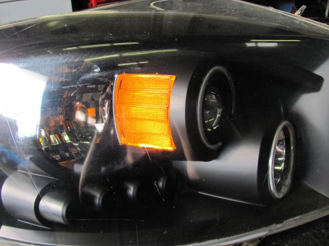 2005 Dodge 3500 - Close-up of a vehicle's headlight assembly, showing the amber turn signal and projector lens.