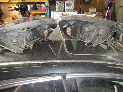2005 Dodge 3500 - Two headlights are shown resting on the roof of a dark vehicle, possibly for repair or replacement.