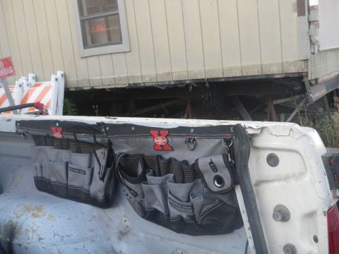 1991 Ford Bronco - A tool belt is attached to the tailgate of a white pickup truck.