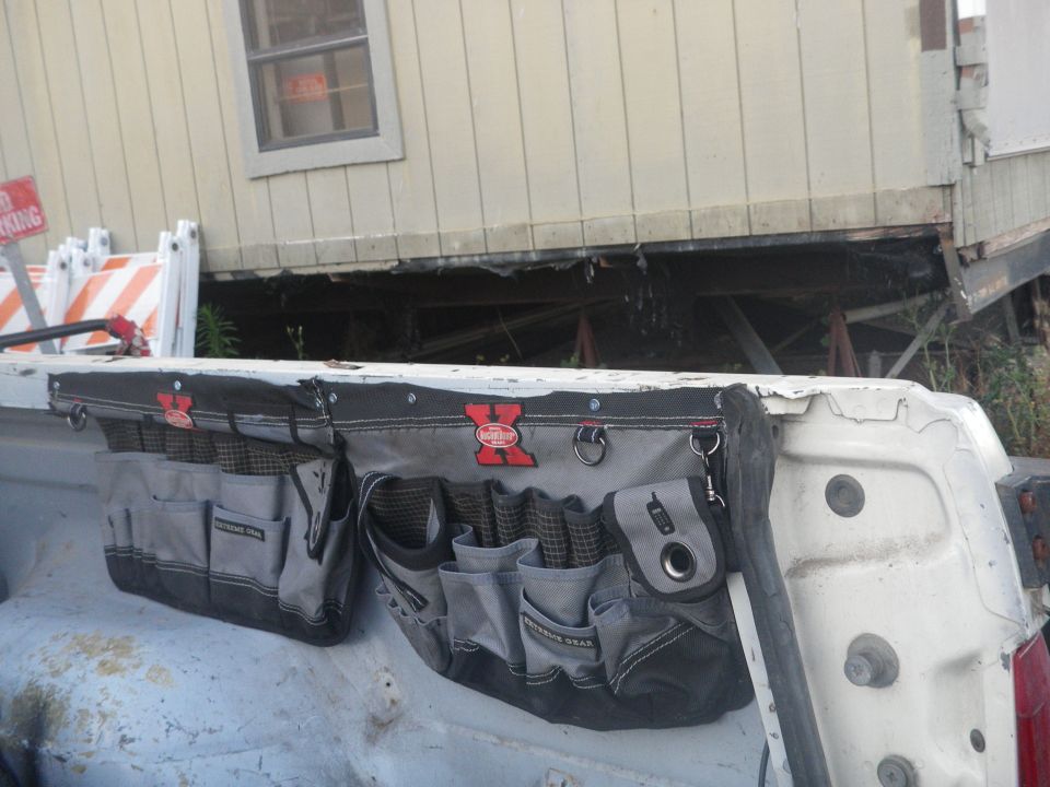 Tool belt attached to the tailgate of a white pickup truck