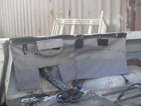 1991 Ford Bronco - A fabric organizer with numerous pockets is attached to the inside of a vehicle's tailgate.