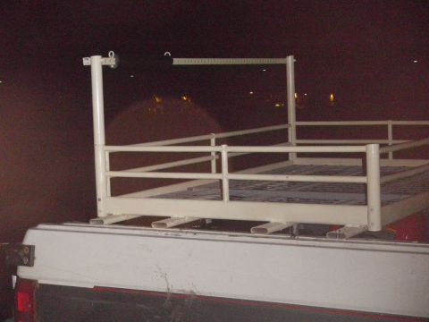 1991 Ford Bronco - A white ladder rack is mounted on the bed of a pickup truck, seen at night.