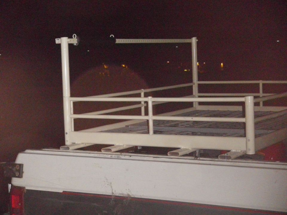 Ladder rack on white pickup truck bed at night