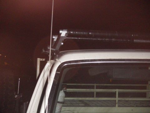 1991 Ford Bronco - A light bar and auxiliary lights are mounted on a rack above the cab of a white truck.