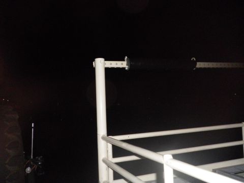 1991 Ford Bronco - A close-up view of a white metal railing and a black bar, set against a dark, indistinct background.