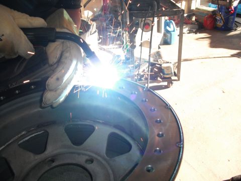 1991 Ford Bronco - A close-up view of a wheel rim being welded, with sparks flying from the welding torch.