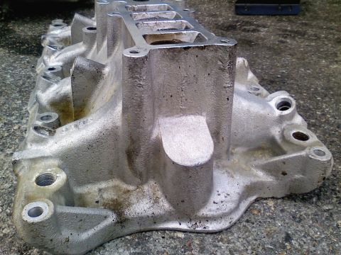 1990 Ford Bronco - This is a close-up view of an aluminum intake manifold, likely a replacement part for a vehicle.