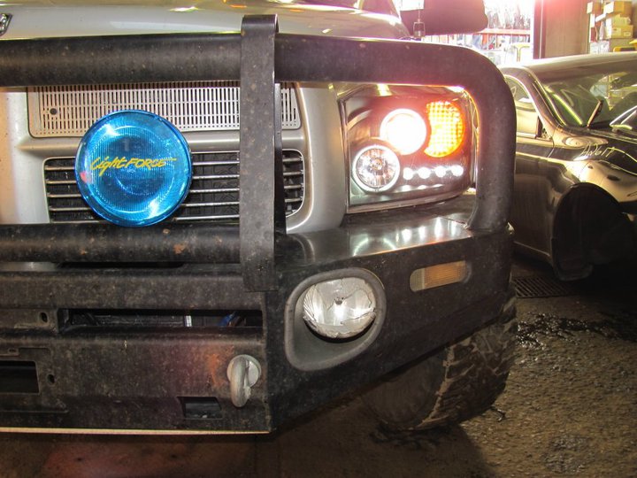 Truck front with blue LightForce driving light and aftermarket headlights