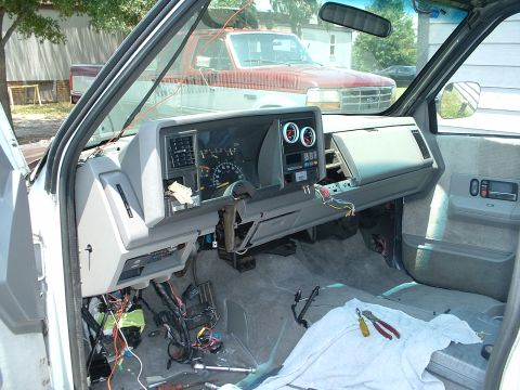 1994 GMC Suburban - The interior of a 1994 GMC Suburban shows a disassembled dashboard with exposed wiring and tools on the floor.