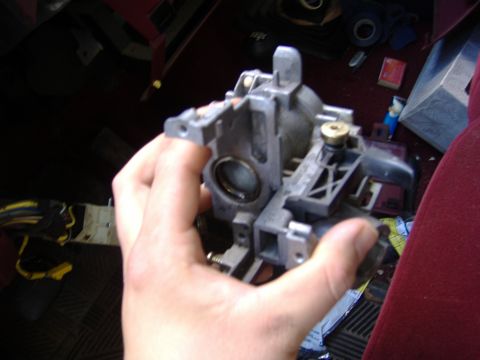 1995 Ford F-150 - Close-up of a steering column component being held, with a glimpse of the vehicle's interior.