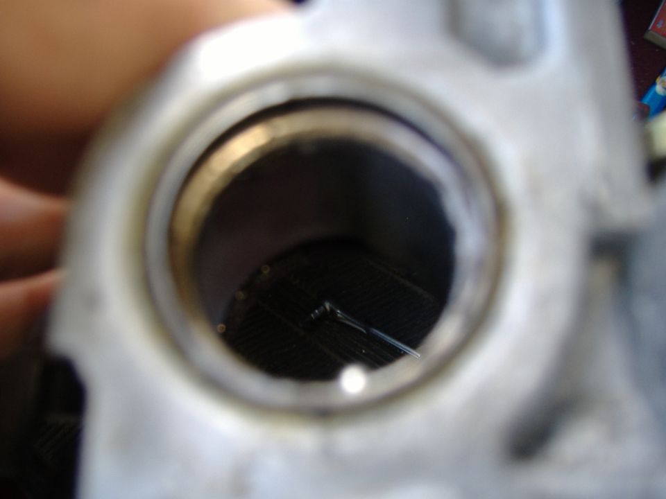 Close-up of a metal steering column component with a black grate inside