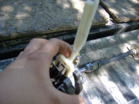 1995 Ford F-150 - A hand manipulates a steering column part against a textured background.