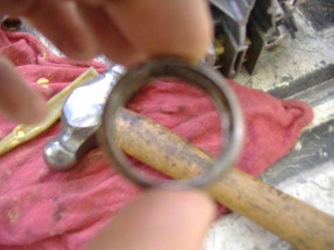 1995 Ford F-150 - A close-up of a steering column bearing is held in focus, with tools and a red cloth in the background.