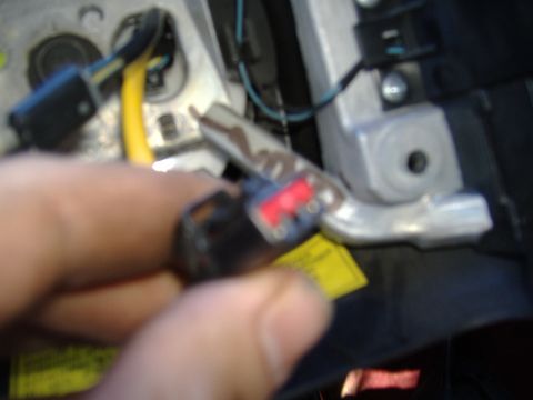 1995 Ford F-150 - Close-up of a steering column wiring harness connector being handled.