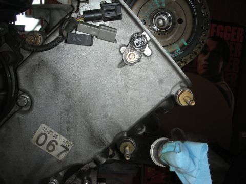 1992 Ford Crown Victoria - Close-up of an engine component with a date sticker, electrical connectors, and a timing chain visible.