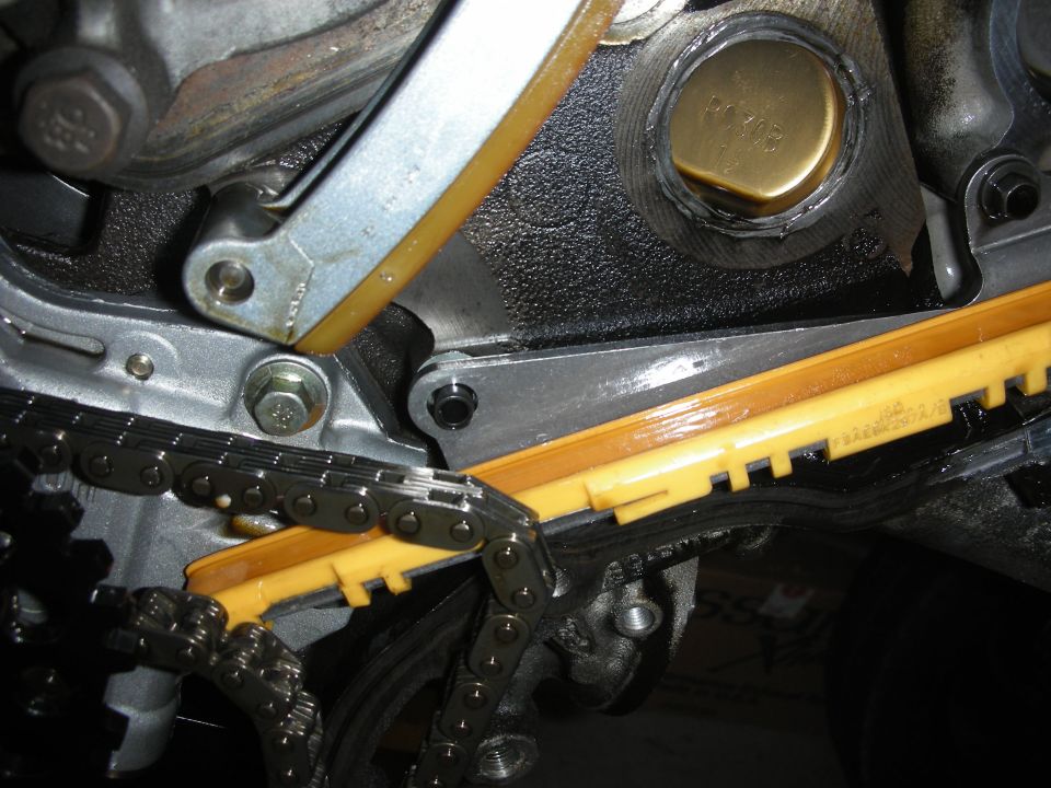 close-up of engine timing chain, tensioner, and guides