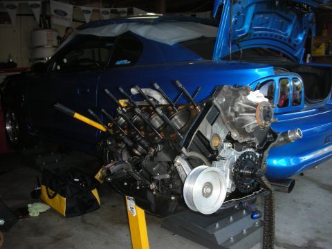1992 Ford Crown Victoria - Engine block assembly in progress, with the car's trunk open and bodywork visible in the background.