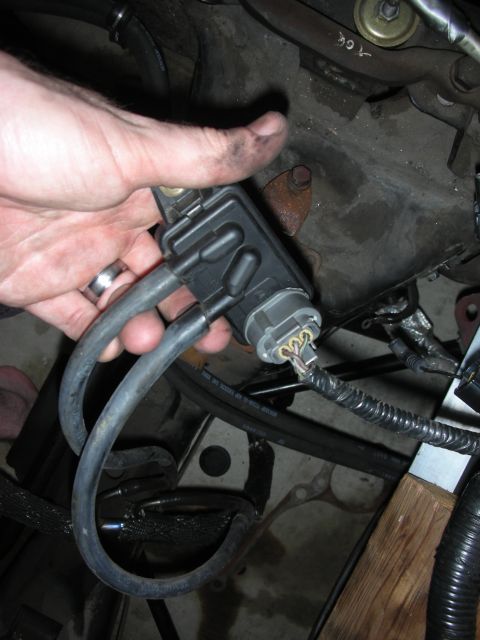 1992 Ford Crown Victoria - Hand holding a car part with hoses and electrical connector attached.