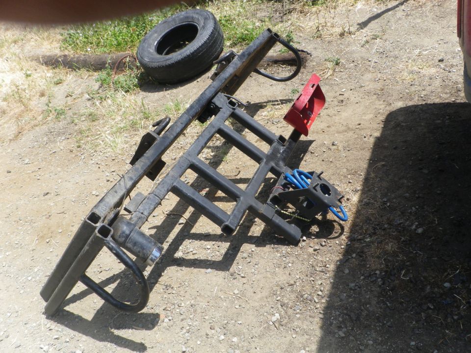 Tire and black trailer hitch rack with red bracket
