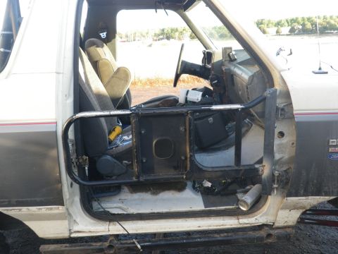 1991 Ford Bronco - Interior view of a 1991 Ford Bronco, modified with custom door bars and roll cage components.