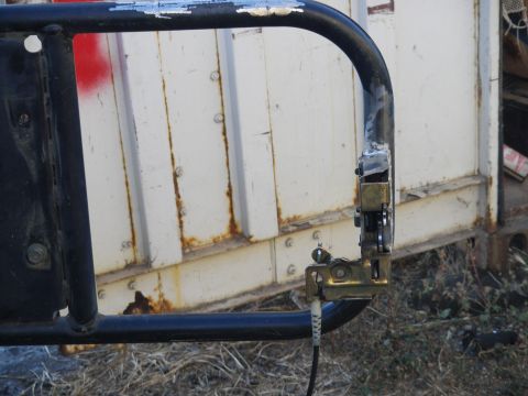 1991 Ford Bronco - Close-up of a vehicle's spare tire carrier mechanism, showing its construction and latching system.