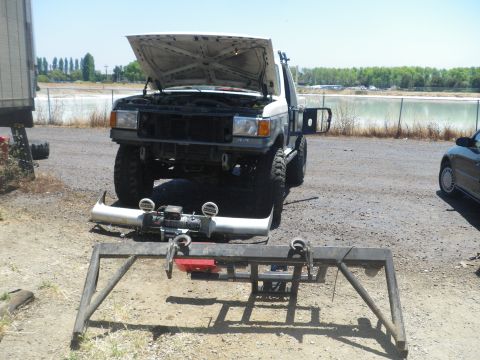 1991 Ford Bronco - A white Ford F-series truck is parked outdoors with its hood open and front bumper removed, revealing a winch.