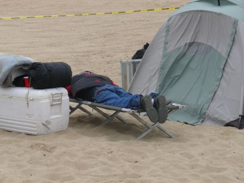 1988 Ford Bronco - A person rests on a cot at a campsite with a cooler and tent nearby.