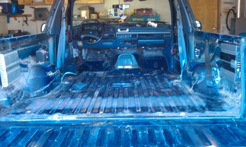 1992 Ford Bronco - The interior of a 1992 Ford Bronco is shown, with the dashboard and empty truck bed visible.